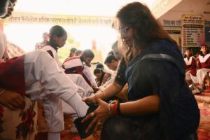 छात्रा को जूते पहनते हुए कलेक्टर अंजू पवन भदौरिया